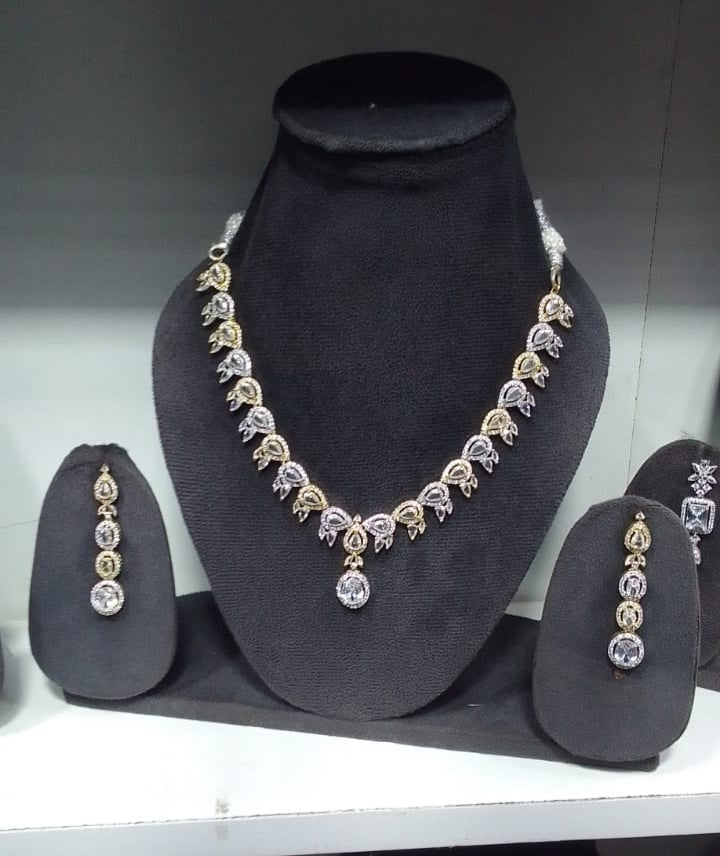 Jewelry set including necklace, earrings, and bangles on a black mannequin bust.